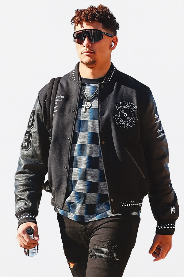 Patrick Mahome wearing black Amiri varsity jacket front look stylish outerwear