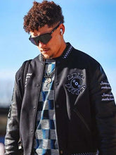 Black Amiri varsity jacket side profile worn by Patrick Mahome casual streetwear