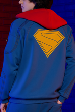 Side view of Superman 2025 blue zip up hoodie for men with iconic S logo and red hood casual activewear